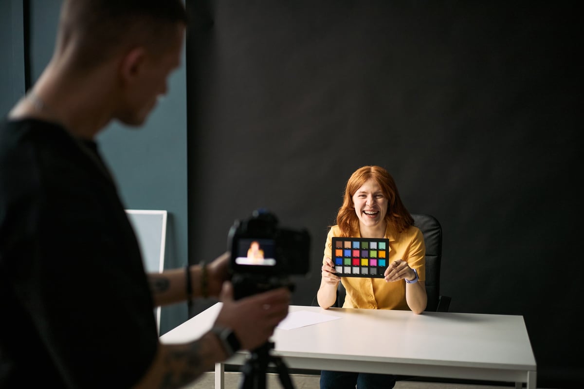 Creadora de contenido grabando video con carta de color